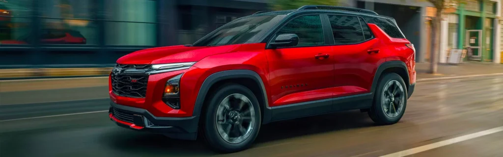 This image shows the 2026 Chevrolet Equinox in a vibrant red color, speeding through a city street, showcasing its dynamic and modern design.