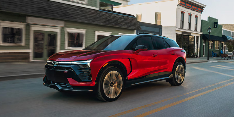 Chevrolet Blazer EV driving down a bustling city street, showcasing its sleek design and urban environment.